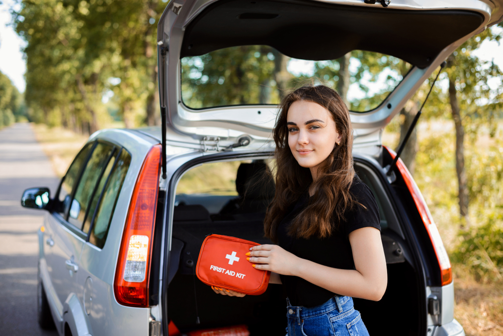 woman holding a first aid kit incase of car accident