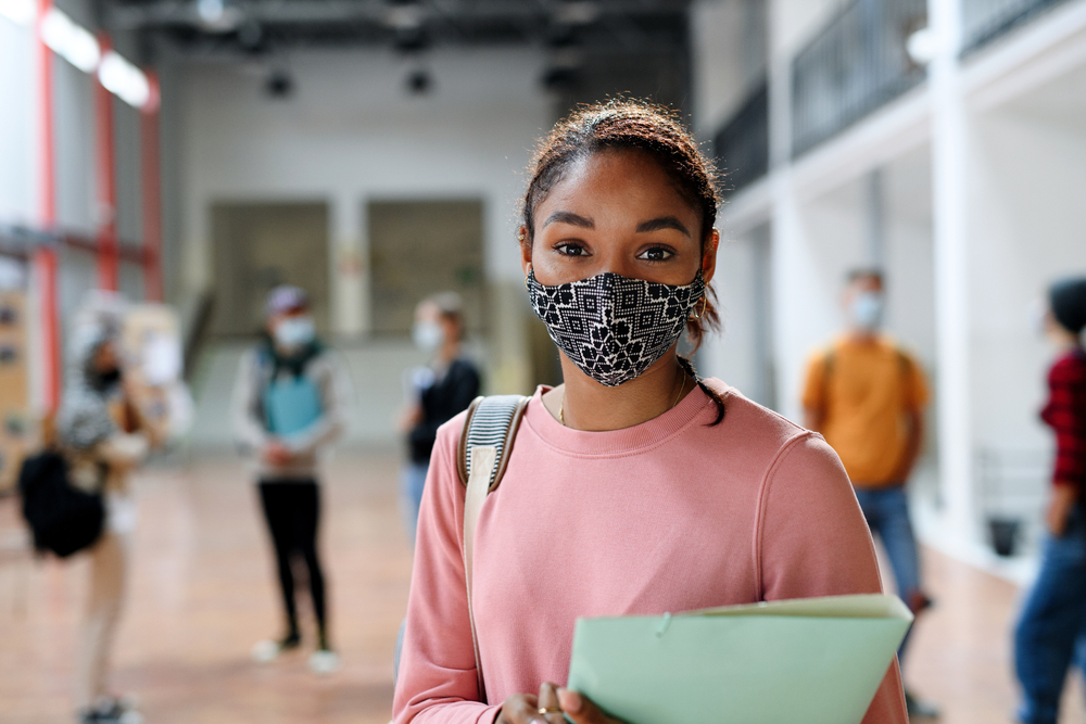 african-american student with face mask back at college or university