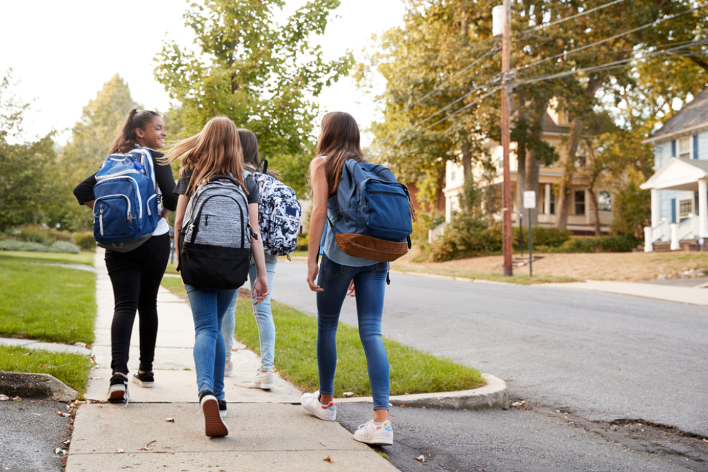 four young teen girls walking to school together