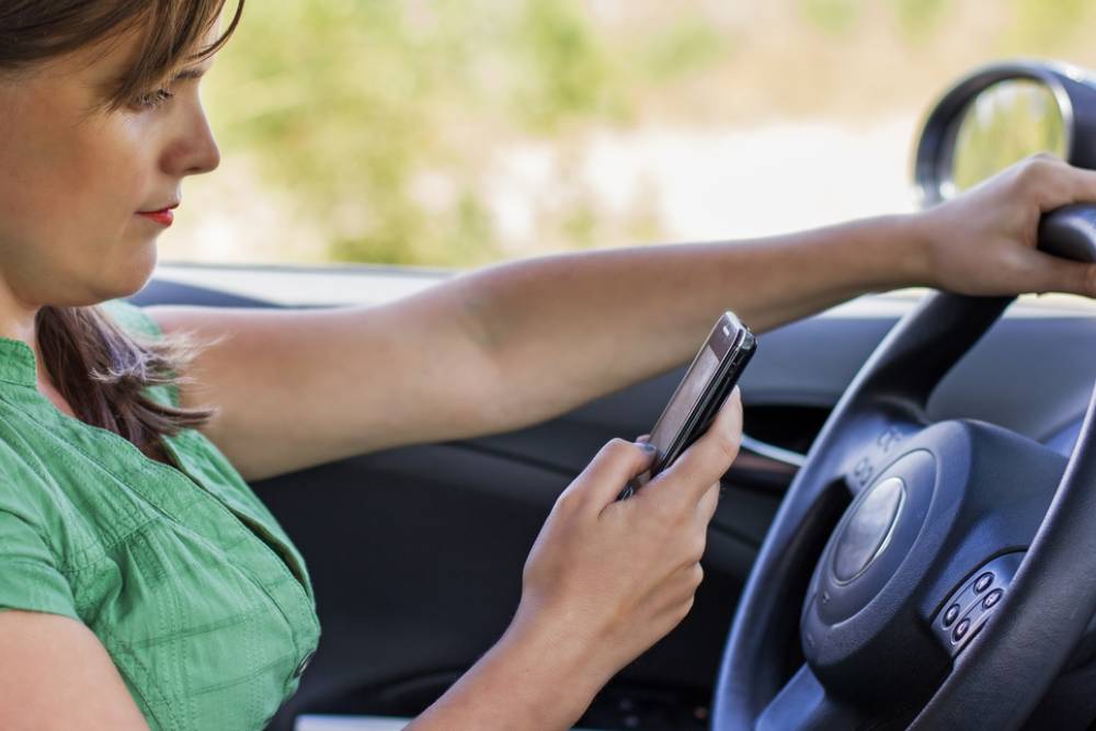 woman driver reading a text message on a mobile