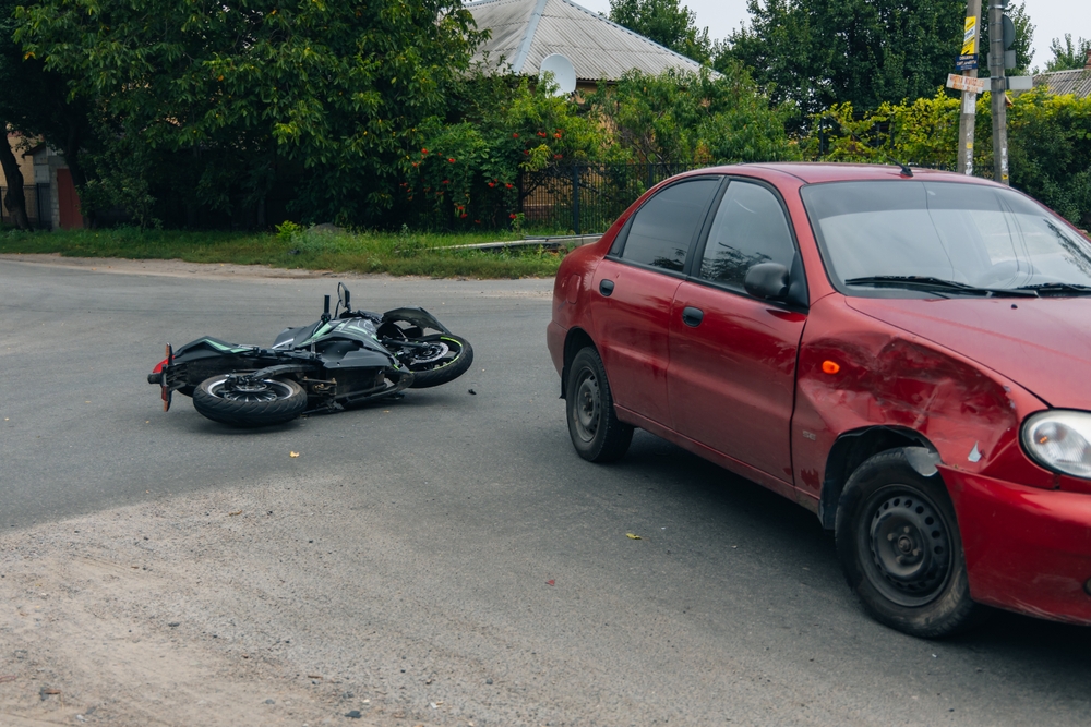 The motorcycle lies on the sidewalk after a road trip. Severe accident