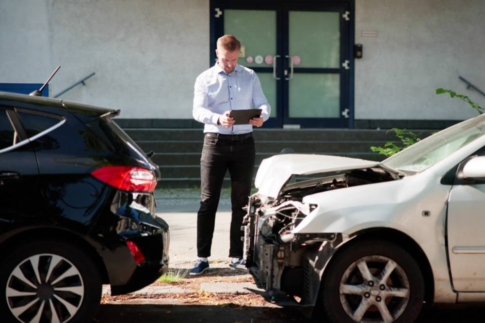 Insurance Investigator Analyzing Car Accident Claim On Tablet Device